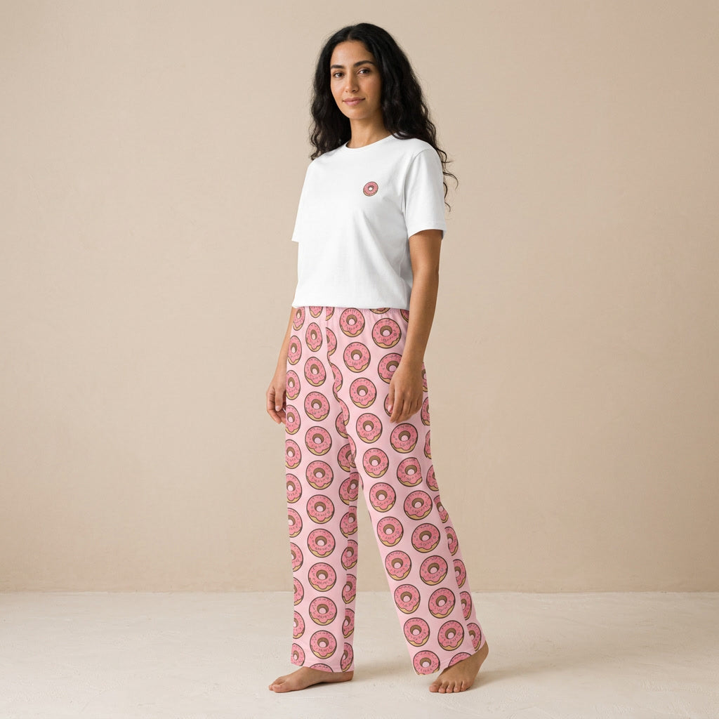 Model wearing a white T-shirt with a small pink donut graphic and pink wide-leg pants with an all-over donut print.