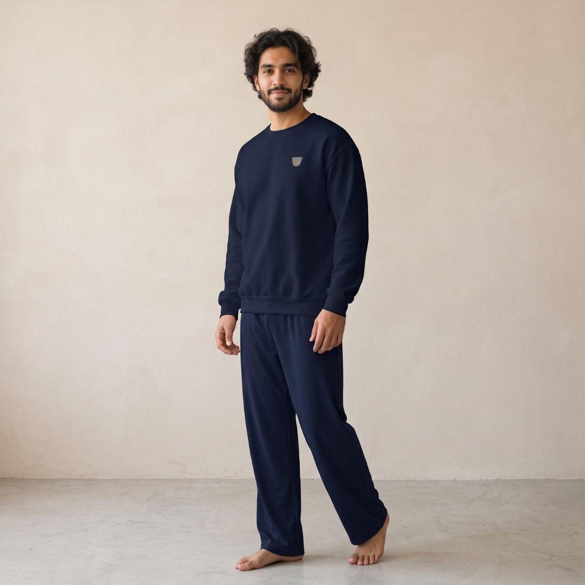 Model wearing a navy sweatshirt with a small finjan coffee cup chest motif and matching wide-leg pants.