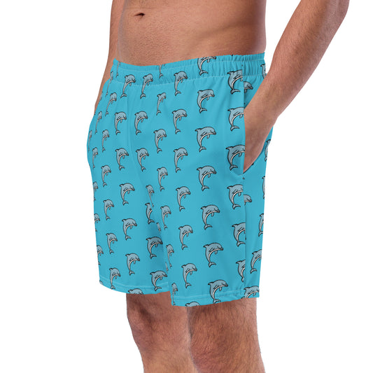 A person wearing blue swim trunks with a dolphin pattern.