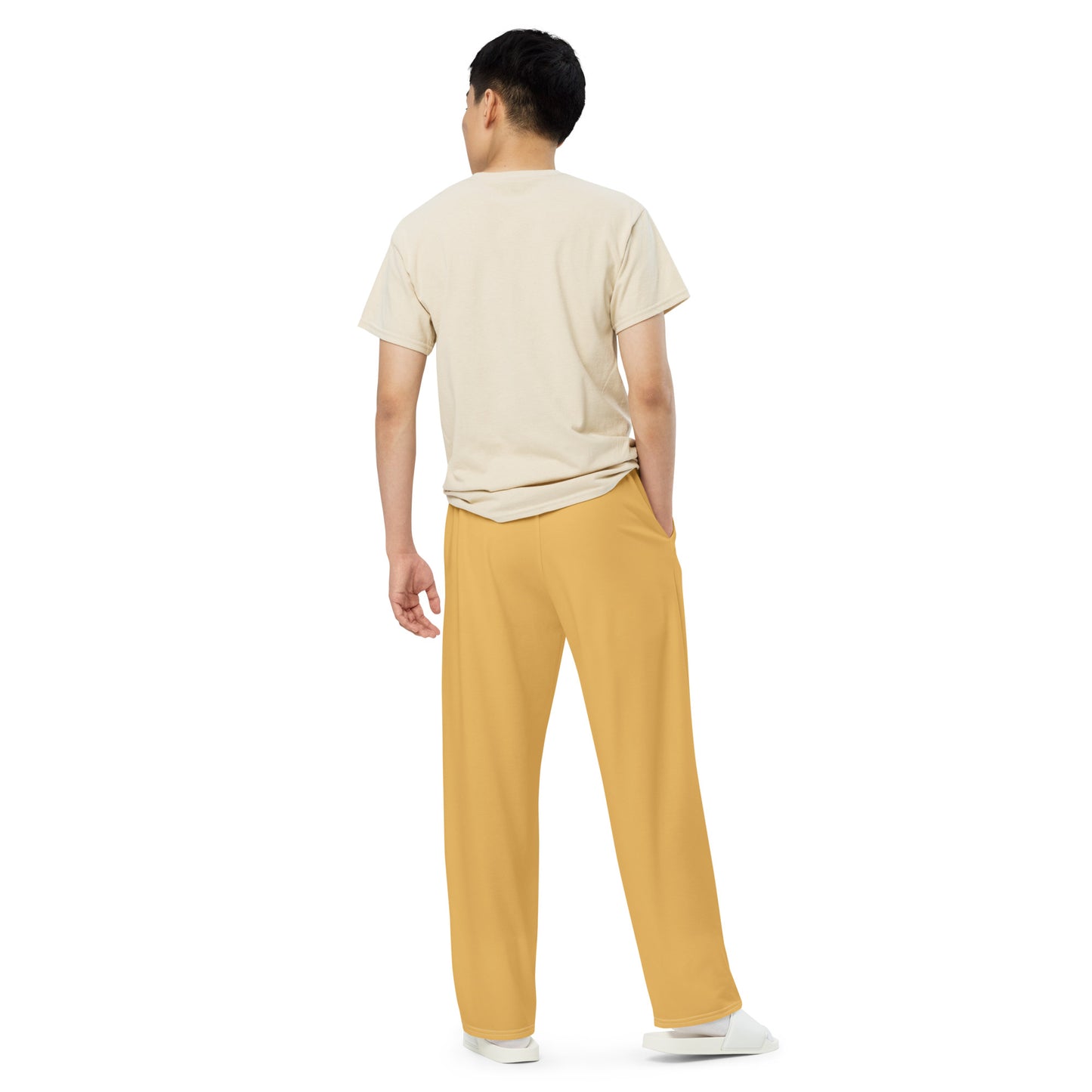 Person wearing a beige t-shirt and yellow pants on a white background
