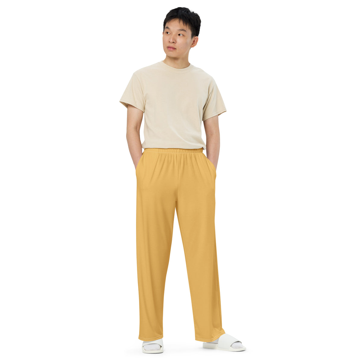 Person wearing a beige t-shirt and yellow pants on a white background