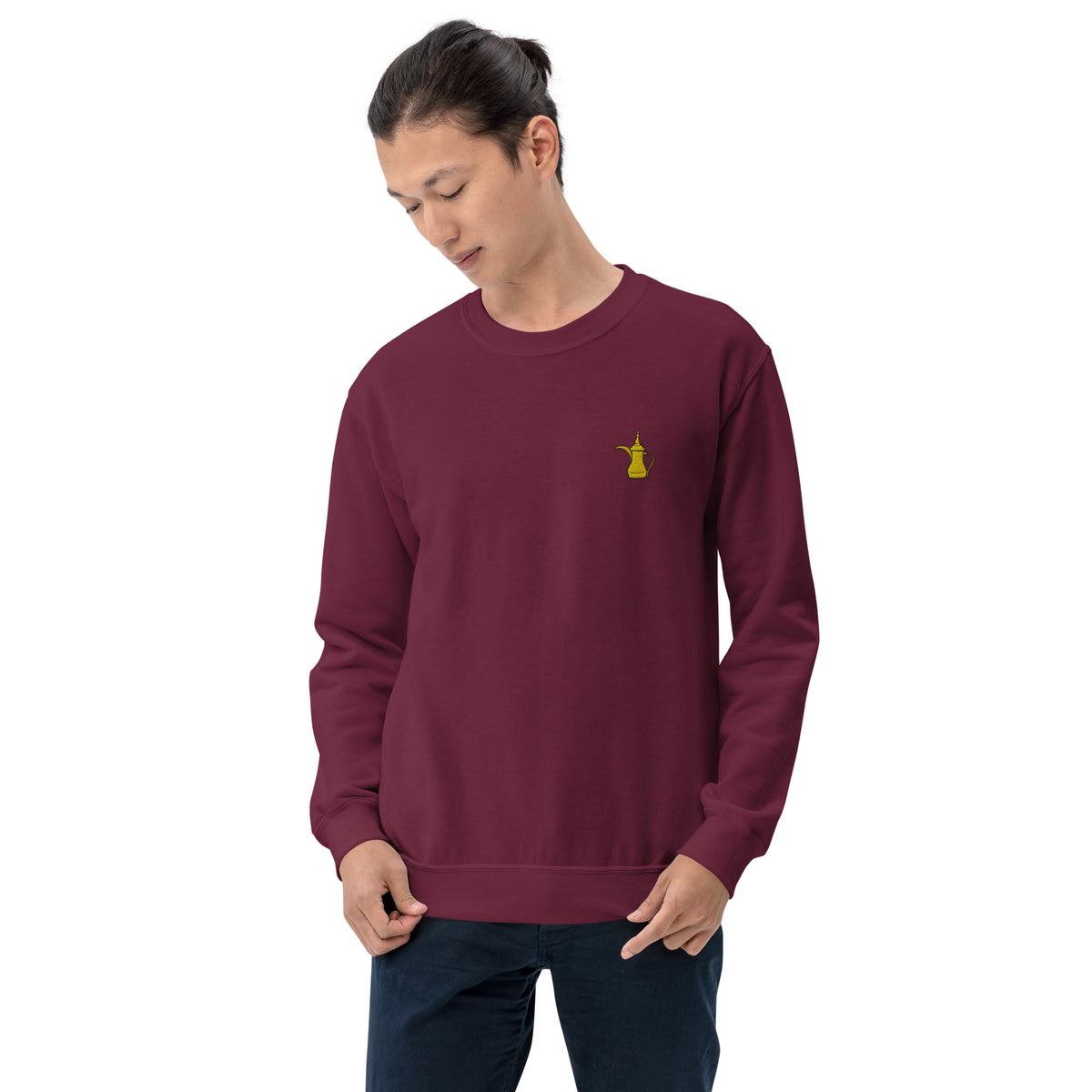 Person wearing a maroon sweatshirt with a yellow dallah on a white background