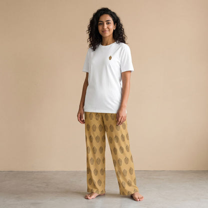Model wearing a white T-shirt with a small traditional coin bank motif and mustard yellow pants with matching prints, front view.