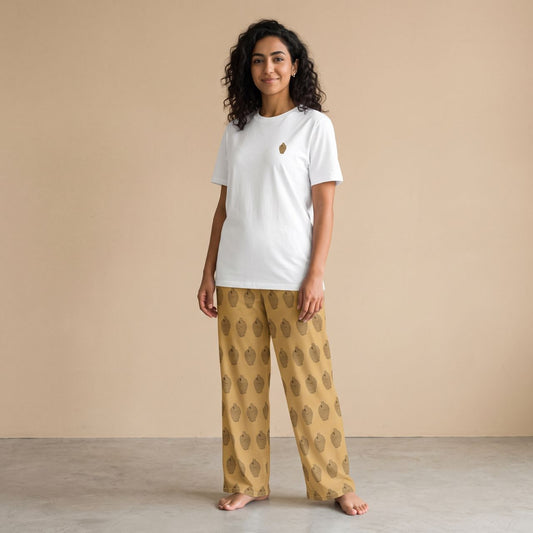 Model wearing a white T-shirt with a small traditional coin bank motif and mustard yellow pants with matching prints, front view.