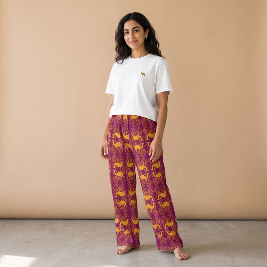 Model wearing a white camel motif T-shirt and purple pants with golden camels and arabesque patterns, front view.