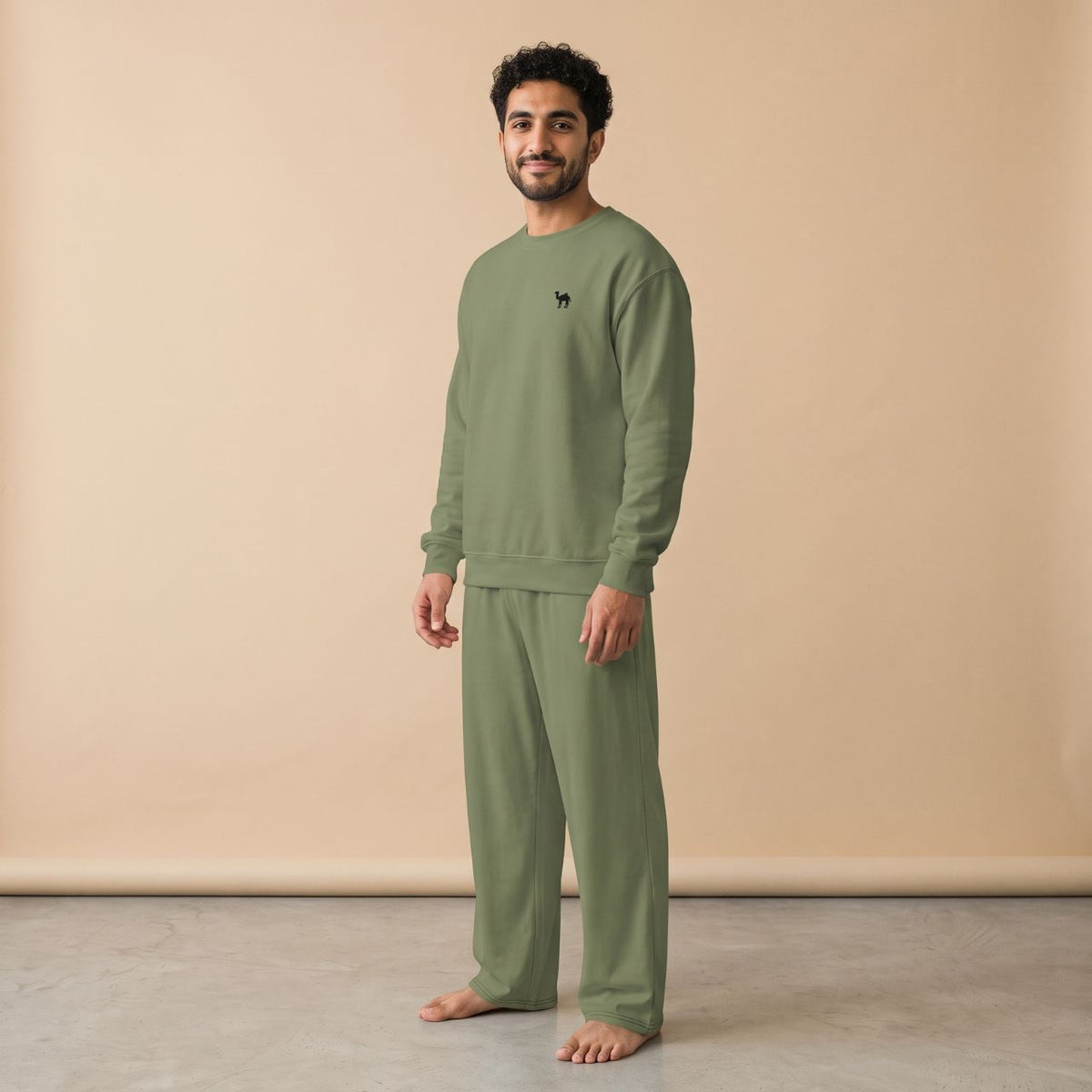 Model wearing a light blue sweatshirt with a small black camel motif and matching plain wide-leg pants, front view.