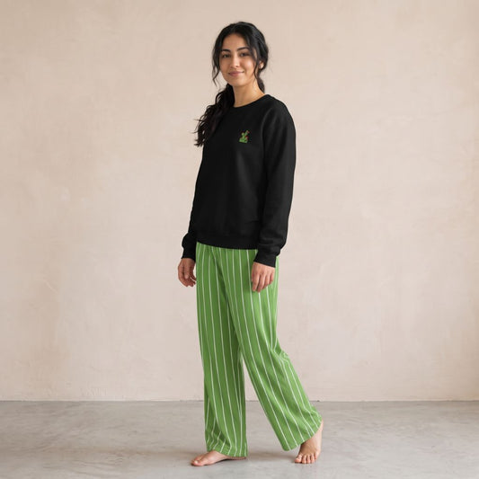 Model wearing a black cactus-embroidered sweatshirt and green wide-leg pants with white vertical stripes.