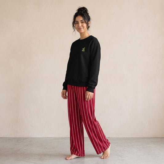 Model wearing a black cactus-embroidered sweatshirt and dark red wide-leg pants with white vertical stripes.