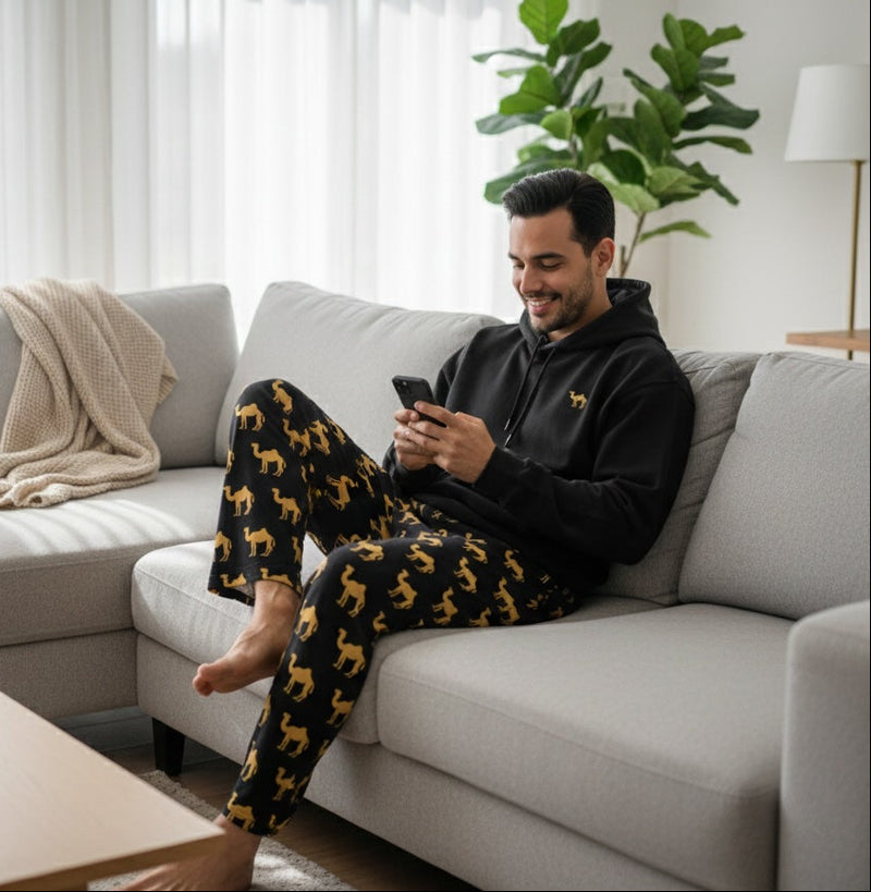 Man sitting on a couch using a smartphone in a living room.