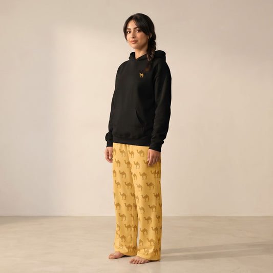 Model wearing a black hoodie with a small camel motif and matching yellow-mustard pants with an all-over tan camel print.