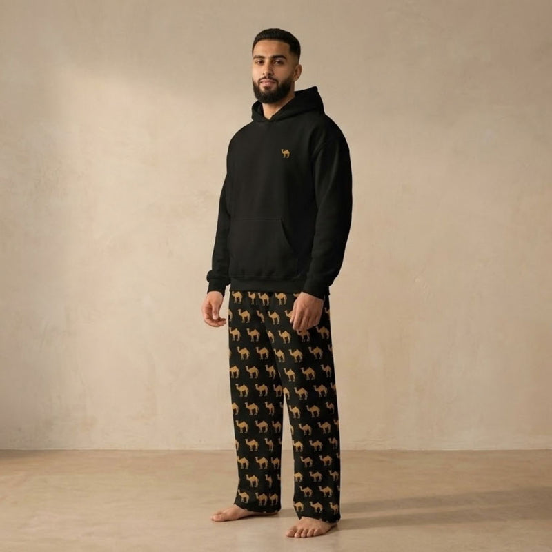 Model wearing a black hoodie with a small camel motif and matching black pants with an all-over tan camel print.