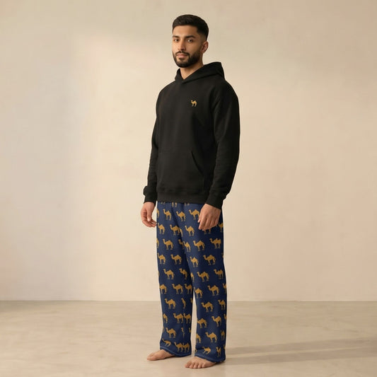 Model wearing a black hoodie with a small camel motif and matching navy pants with an all-over tan camel print.
