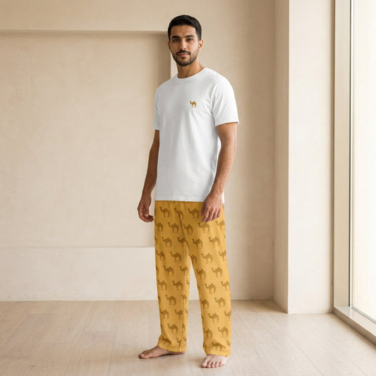 Male model wearing a white T-shirt with a small camel motif and mustard-yellow wide-leg pants with an all-over camel print.