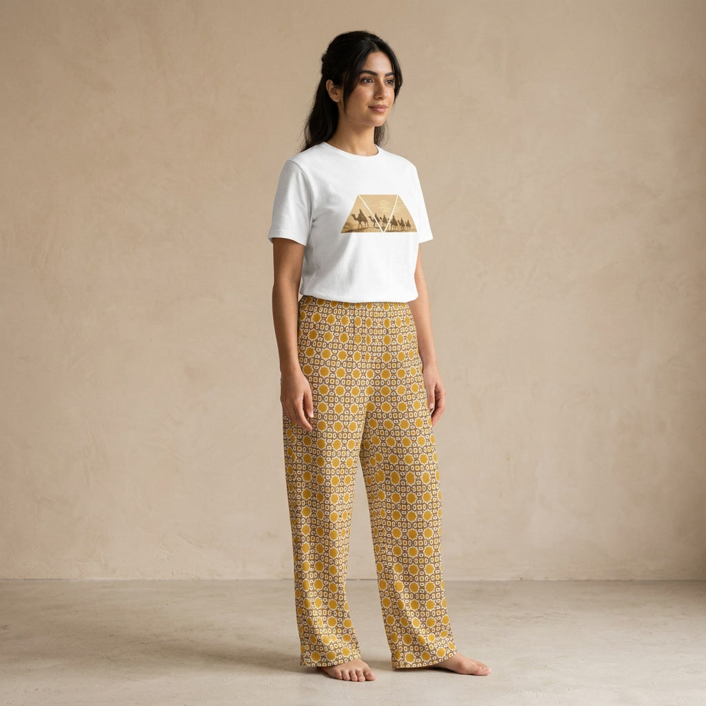 Model wearing a white Desert Voyage graphic T-shirt and mustard-gold Andalusian Star geometric-print wide-leg pants.
