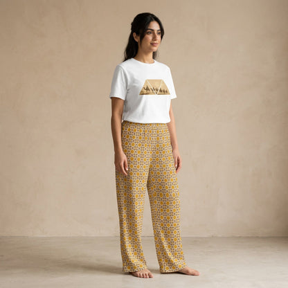 Model wearing a white Desert Voyage graphic T-shirt and mustard-gold Andalusian Star geometric-print wide-leg pants.