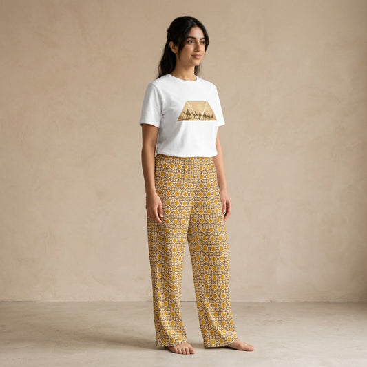 Model wearing a white Desert Voyage graphic T-shirt and mustard-gold Andalusian Star geometric-print wide-leg pants.