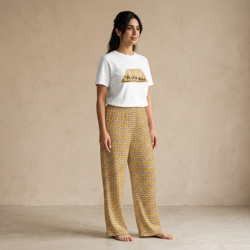 Model wearing a white Desert Voyage graphic T-shirt and mustard-gold Andalusian Star geometric-print wide-leg pants.