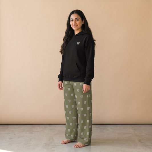 Model wearing a black hoodie with a small finjan cup motif and khaki green pants with white finjan cup prints, front view.
