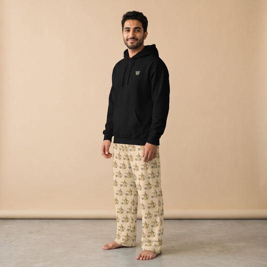 Model wearing a black finjan motif hoodie and cream pants with Arabic coffee pot and finjan cup prints, front view.