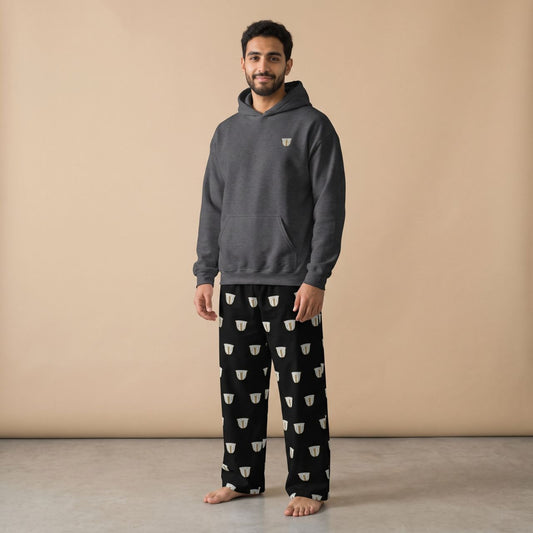 Model wearing a dark grey hoodie with a small finjan cup motif and black pants with white finjan cup prints, front view.