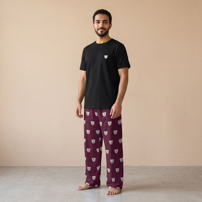 Model wearing a black T-shirt with a small finjan cup motif and maroon pants with white finjan cup prints, front view.