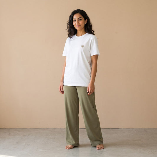 Model wearing a white T-shirt with a small finjan cup motif and plain khaki wide-leg pants, front view.