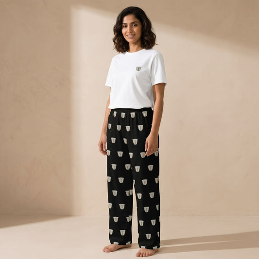 Model wearing the Finjan set: a white T-shirt with a small coffee cup motif and black wide-leg pants with a repeating white coffee cup print.