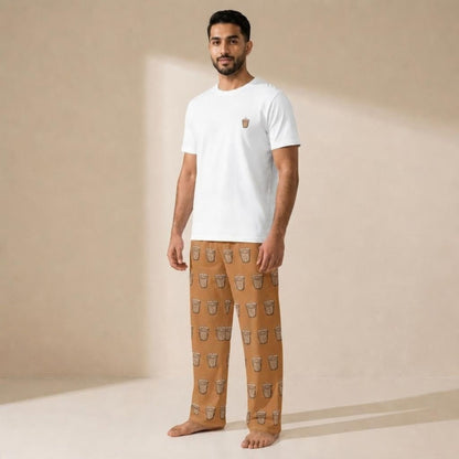 Model wearing a white Karak T-shirt with a small tea cup motif and tan pants patterned with tea cups.