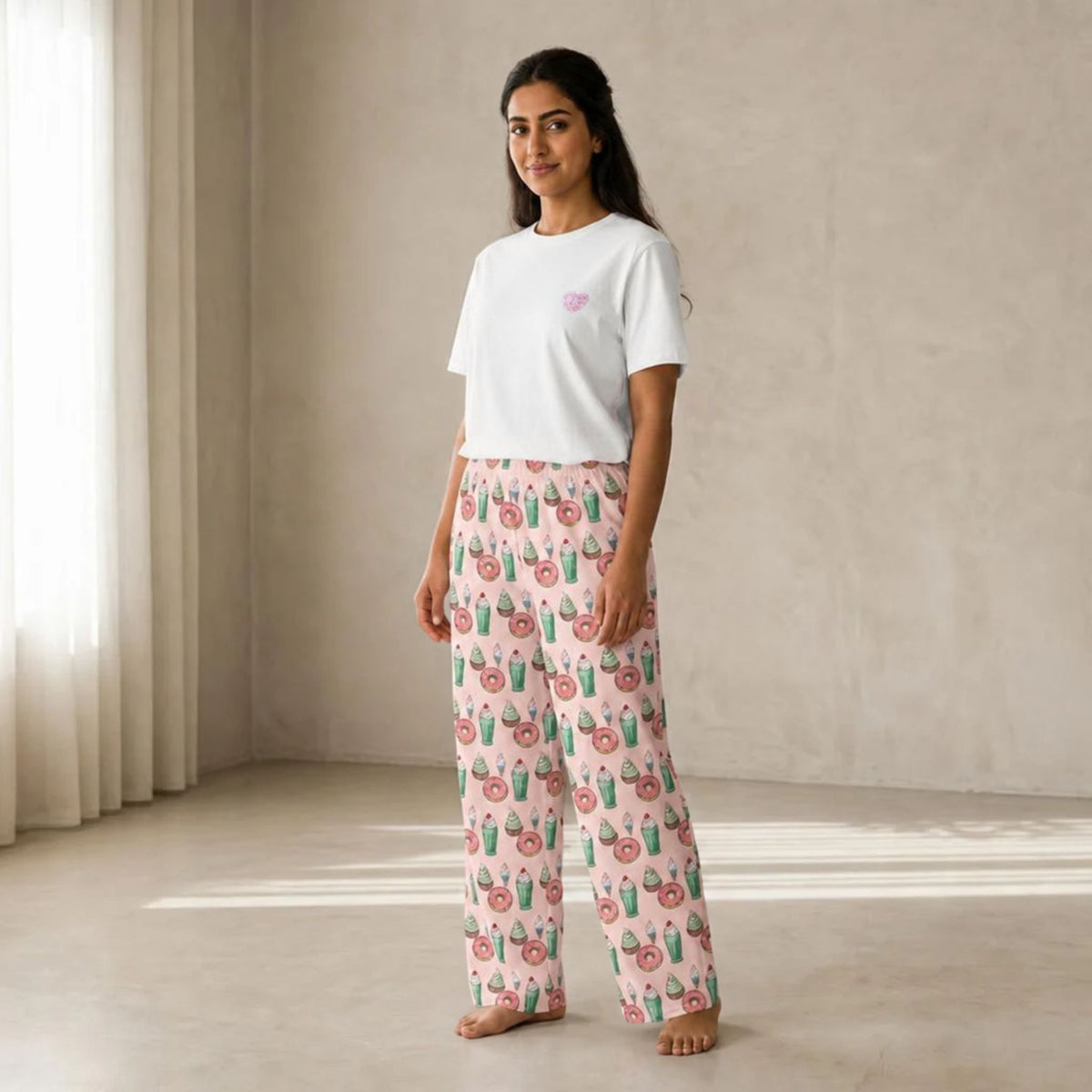 Model wearing the Love for Desserts set, featuring a white T-shirt with a small pink chest graphic and pink wide-leg pants with a colourful dessert print.