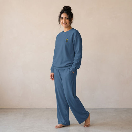 Model wearing an indigo blue sweatshirt with a small Mubkhar chest motif and matching wide-leg pants.