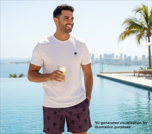 Man holding a drink by a pool with palm trees and city skyline in the background