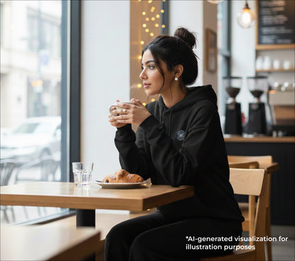 Woman sitting at a cafe table with a cup and pastry