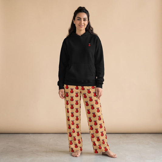 Model wearing a black hoodie with a small red tea glass motif and beige pants with red tea glass prints, front view.
