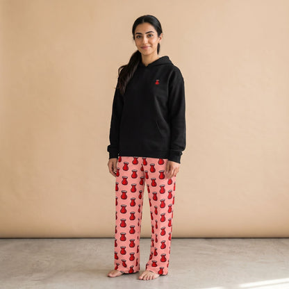 Model wearing a black hoodie with a small red tea glass motif and pink pants with red tea glass prints, front view.