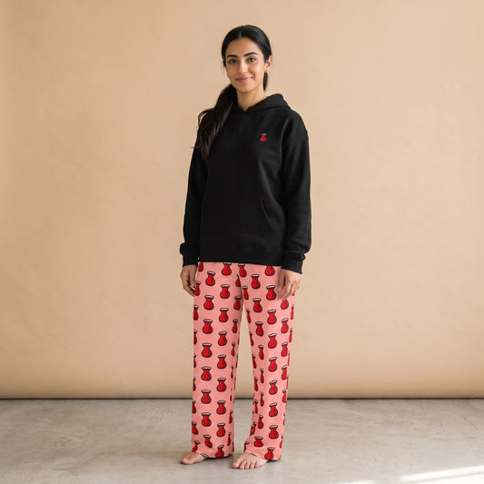 Model wearing a black hoodie with a small red tea glass motif and pink pants with red tea glass prints, front view.