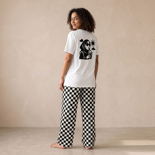 Model wearing a white Refreshments graphic T-shirt and black-and-white checkerboard pants, shown from the back.