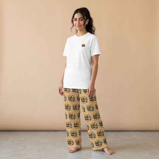 Model wearing a white T-shirt with a small s’more motif and beige pants with s’mores and hot chocolate prints, front view.