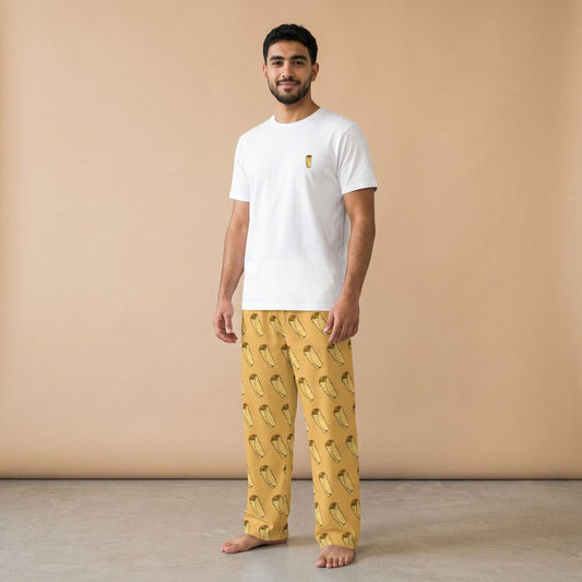 Model wearing a white T-shirt with a small shawarma motif and mustard yellow shawarma-print pants, front view.