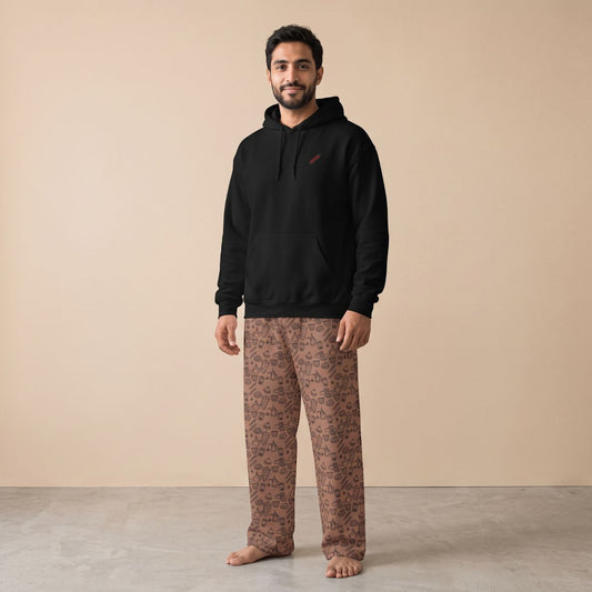 Model wearing a black hoodie with a small tikka skewer motif and brown pants with an all-over food print, front view.