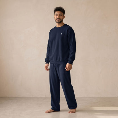 Model wearing a navy sweatshirt with a small white palm tree chest motif and matching wide-leg pants.