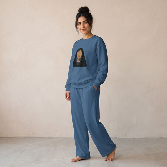 Model wearing an indigo blue sweatshirt featuring a woman in a golden burqa and matching wide-leg pants.