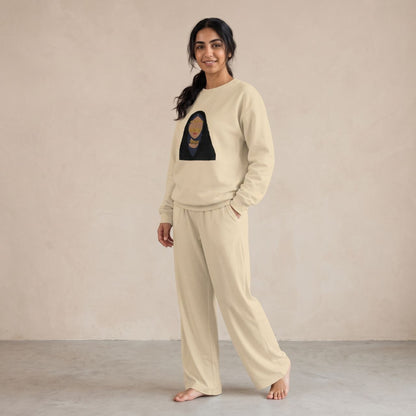 Model wearing a sand sweatshirt featuring a woman in a golden burqa and black headscarf, with matching wide-leg pants.